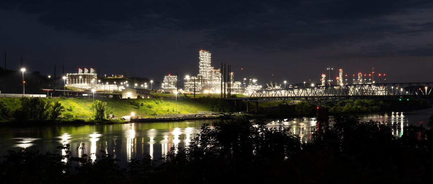 Nighttime photo of Shell Petrochemical Plant in Beaver, PA 6/3/22. Bright lights on industrial towers reflect off of river below.